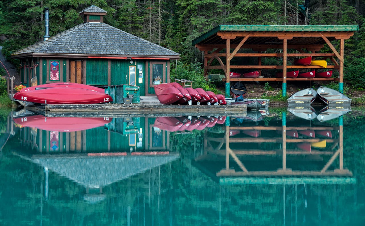 Peaceful scene of a lakeside dock with canoes and reflections in Field, BC, Canada.
